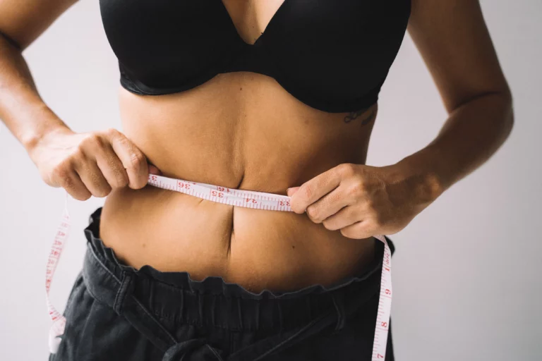 Žena mjeri obujam struka krojačkom trakom zbog debljanja u menopauzi