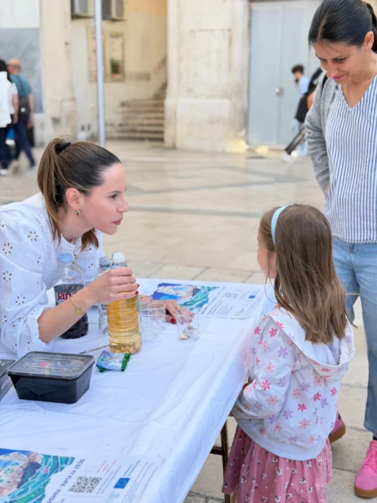 Žena drži bocu kvasine u ruci spremna pokazati pokus djevojčici.